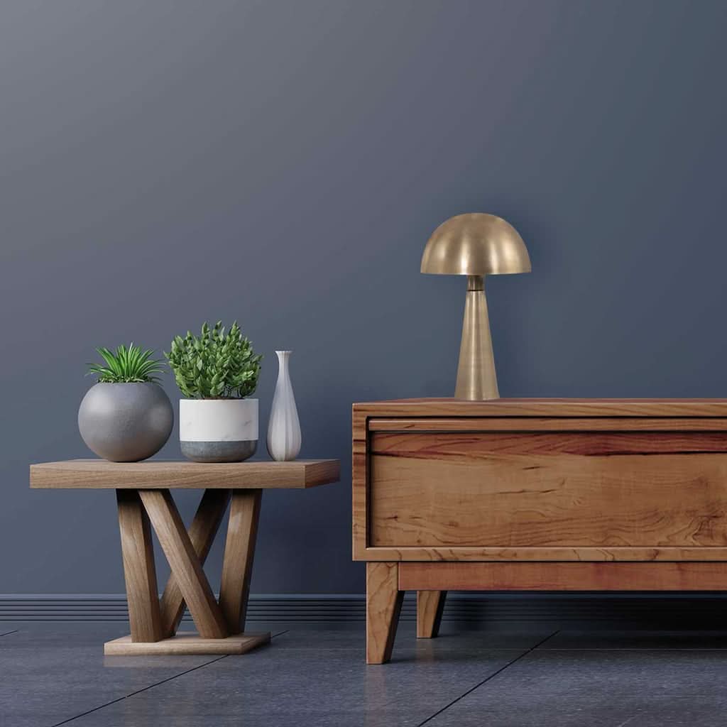 Mise en ambiance sur un buffet en bois, mur gris avec plante et vase