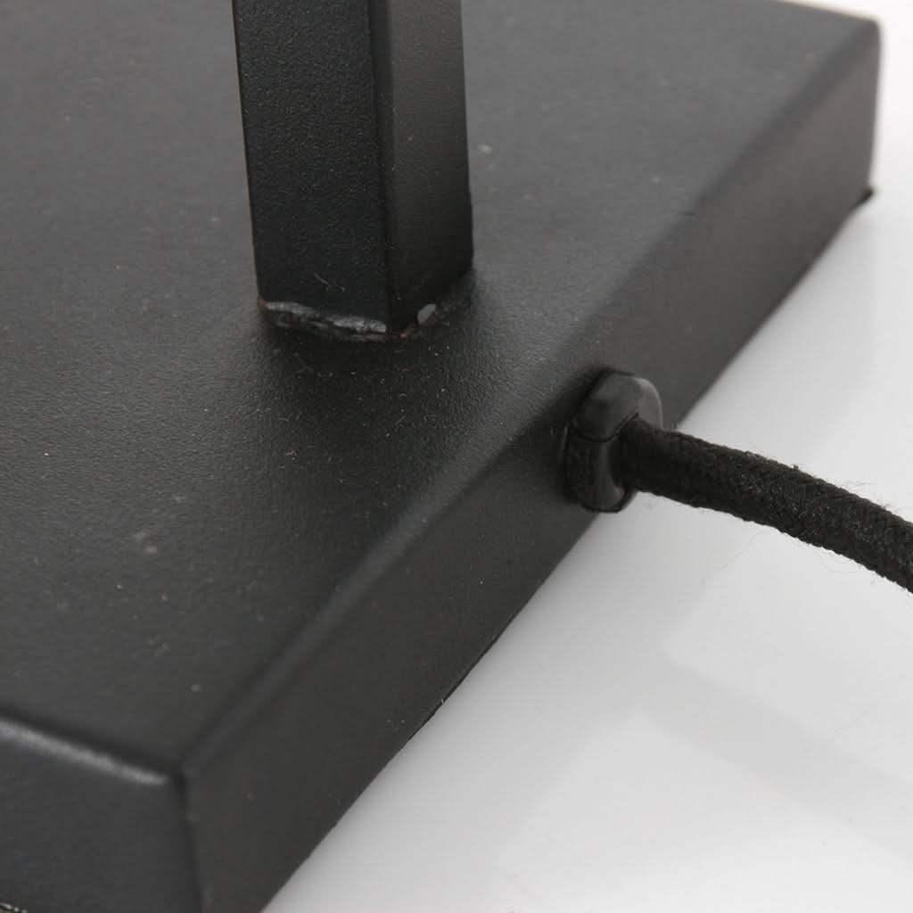 Gros plan sur la base rectangulaire noire et le cordon textile gainé sortant.