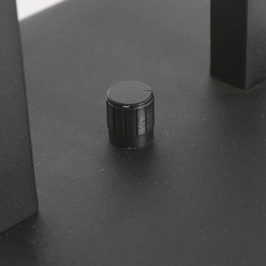 Gros plan sur le bouton rotatif noir strié fixé sur la plaque de base du luminaire.