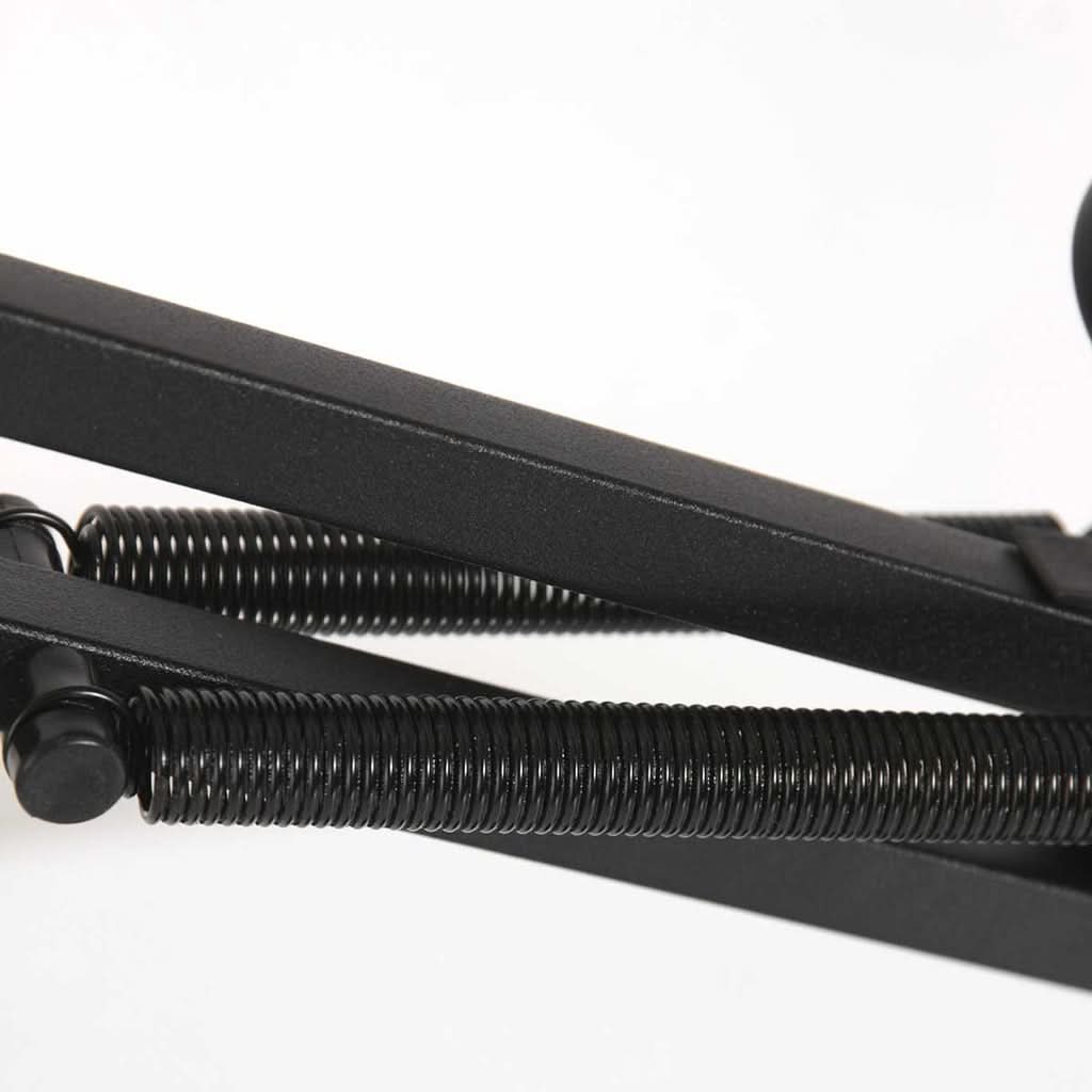 Détail des ressorts métalliques et des bras pliants noirs de la lampe.