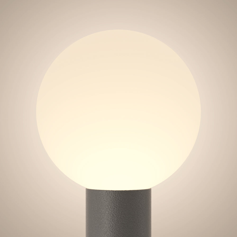 Vue rapprochée du globe lumineux et de la base cylindrique grise.