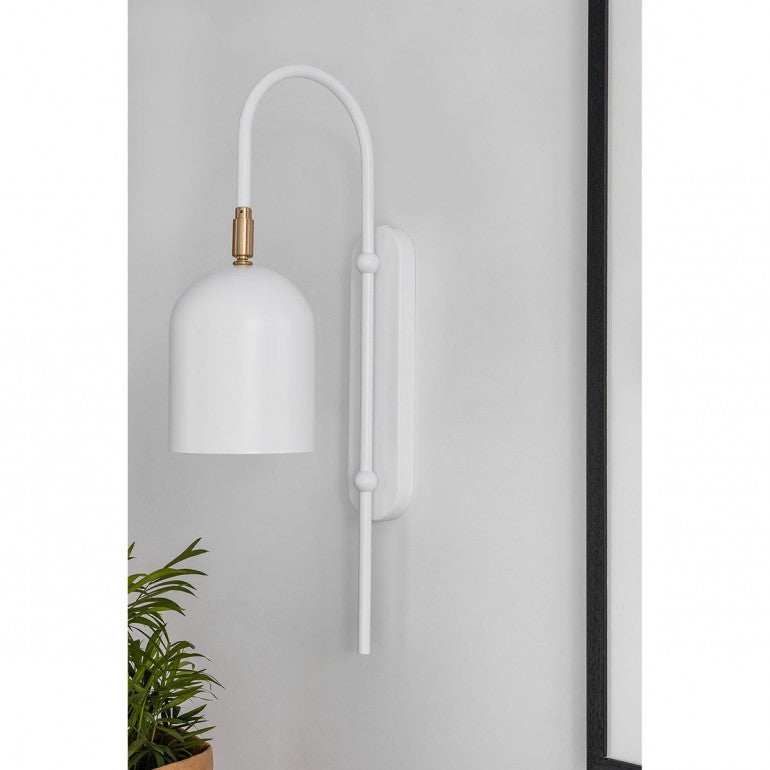 Applique blanche installée sur un mur gris clair, près d'une plante verte en pot