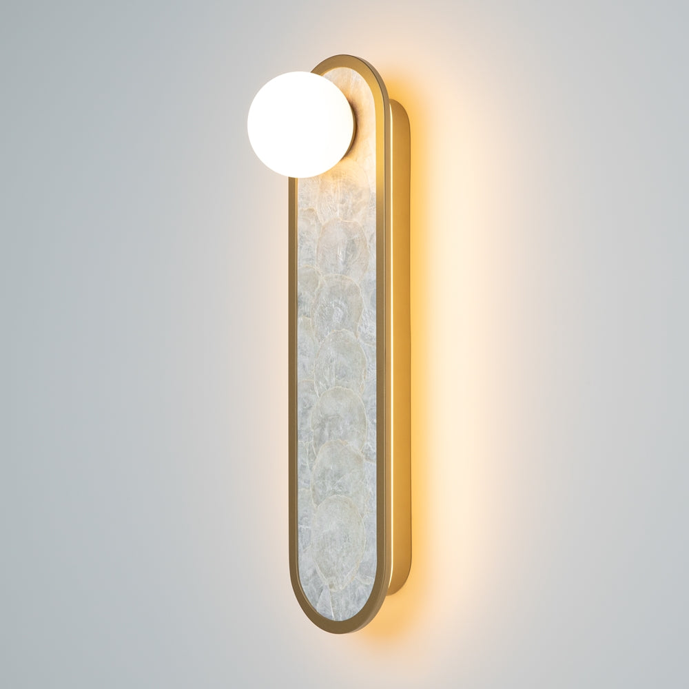 Vue de trois quarts sur mur gris, halo lumineux doré autour du luminaire allumé