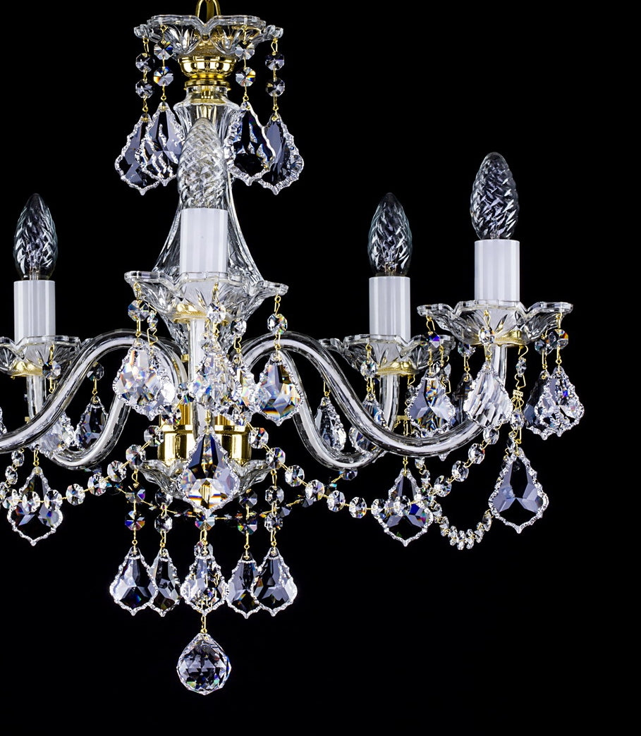 Lustre en cristal à cinq bras, vue de face sans fixation visible, fond noir.