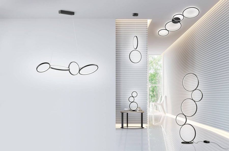 Vue large d'un intérieur avec plusieurs luminaires à cercles noirs, plafond et sol.