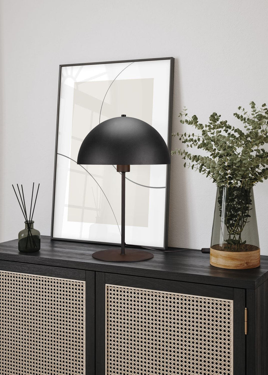 Vue rapprochée de la lampe posée sur le buffet cannage avec eucalyptus