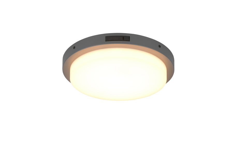 Gros plan du luminaire allumé, boîtier anthracite et diffuseur blanc uniforme.