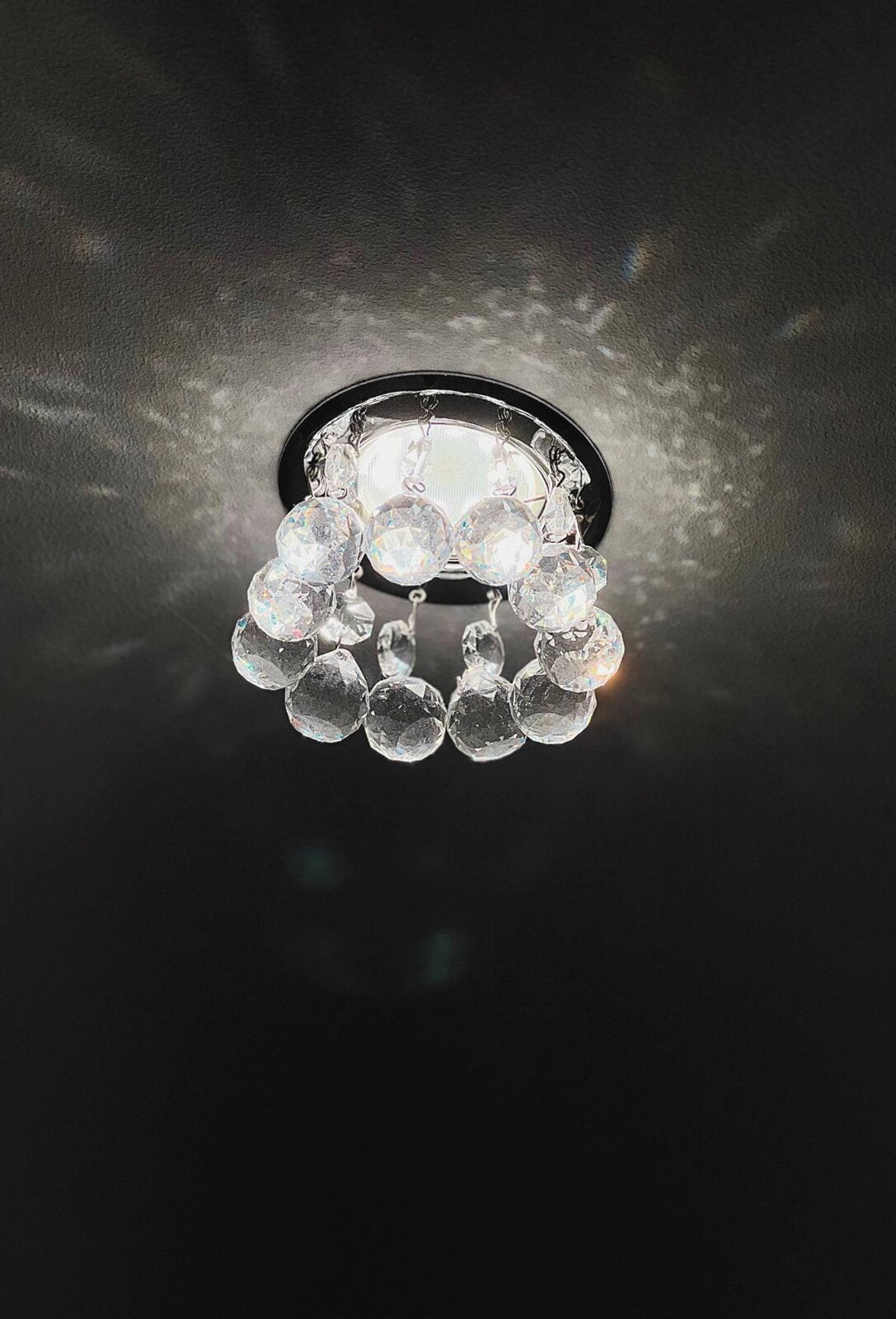 Mise en ambiance au plafond sombre, lumière scintillante diffusée par les cristaux taillés.