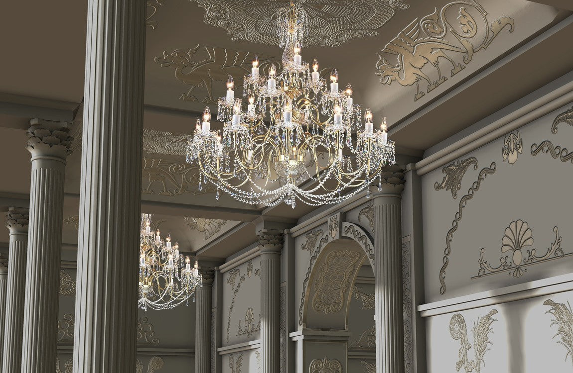 Lustre suspendu au plafond d'un salon classique mouluré, colonnes et stucs dorés en volume.