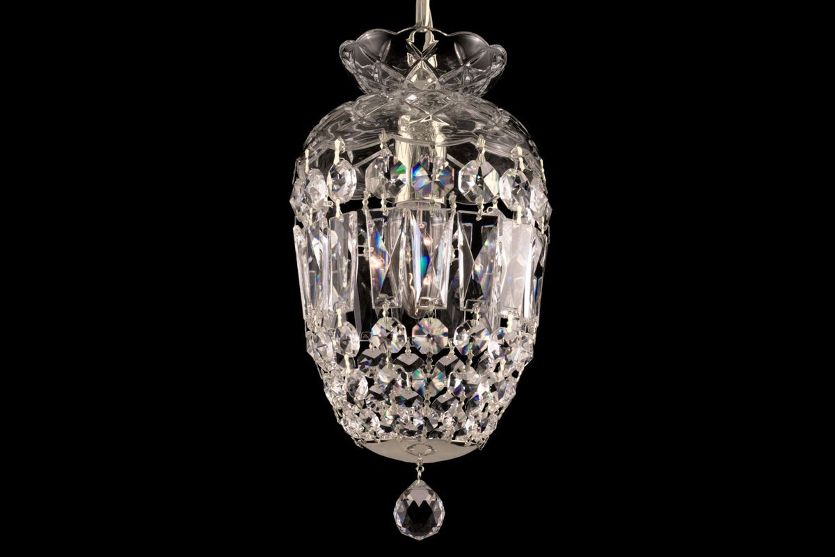 Gros plan du luminaire en cristal taillé, éclats irisés des pendeloques en verre