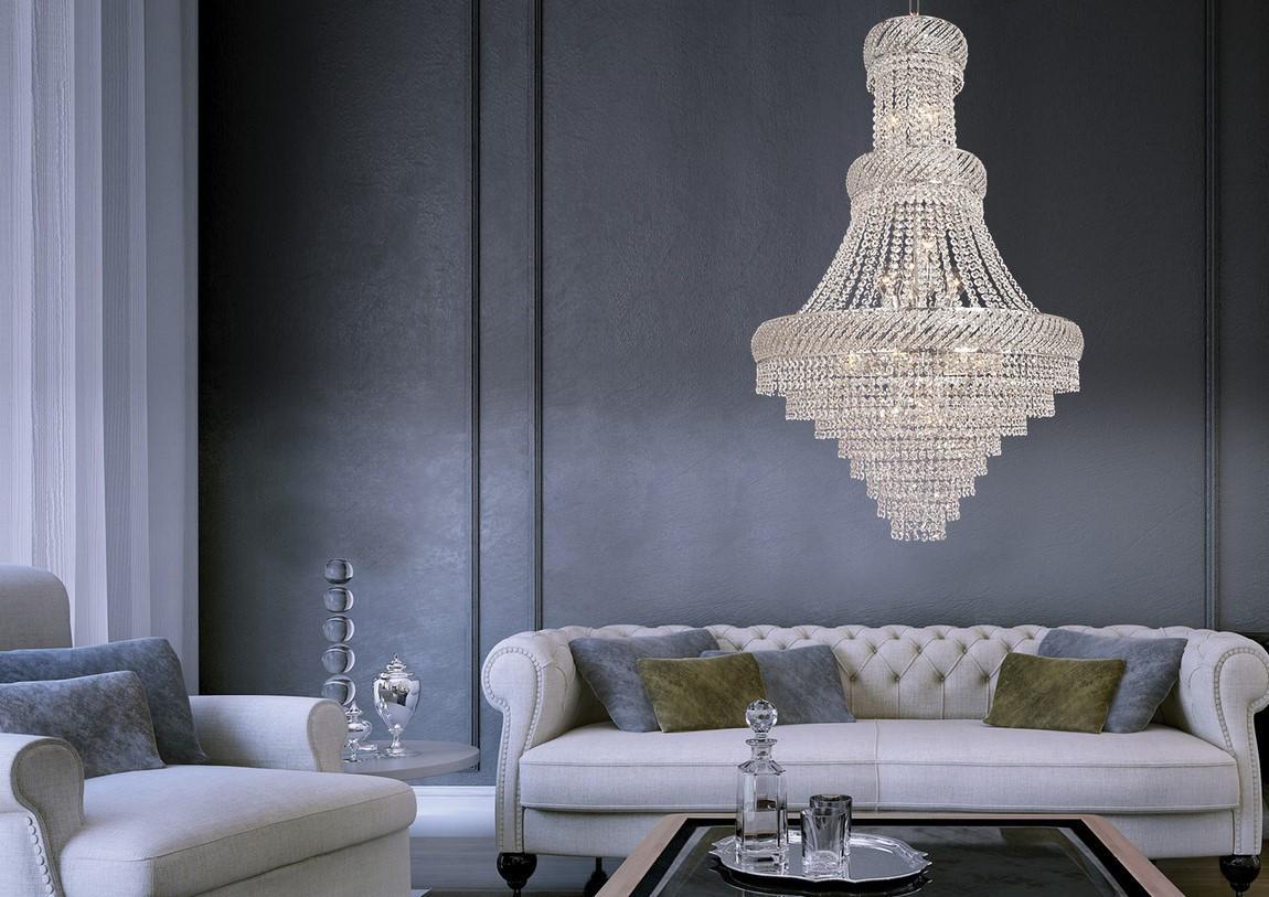 Intérieur chic et sombre, lustre allumé au-dessus d'un canapé capitonné beige