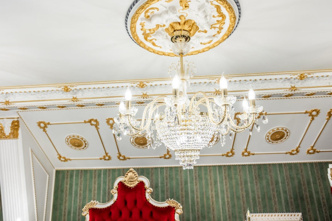 Vue en contre-plongée du lustre fixé sous une rosace de plafond dorée