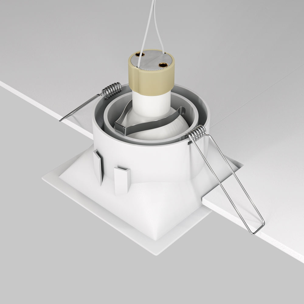 Vue d'installation du spot encastré avec ressorts et corps cylindrique dans le plafond.