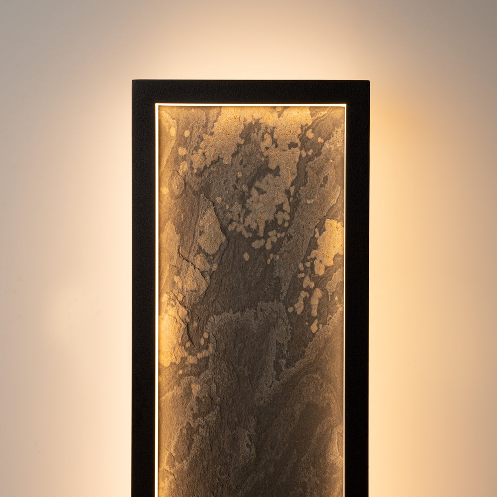 Gros plan du haut du panneau allumé, texture minérale dorée révélée par la lumière