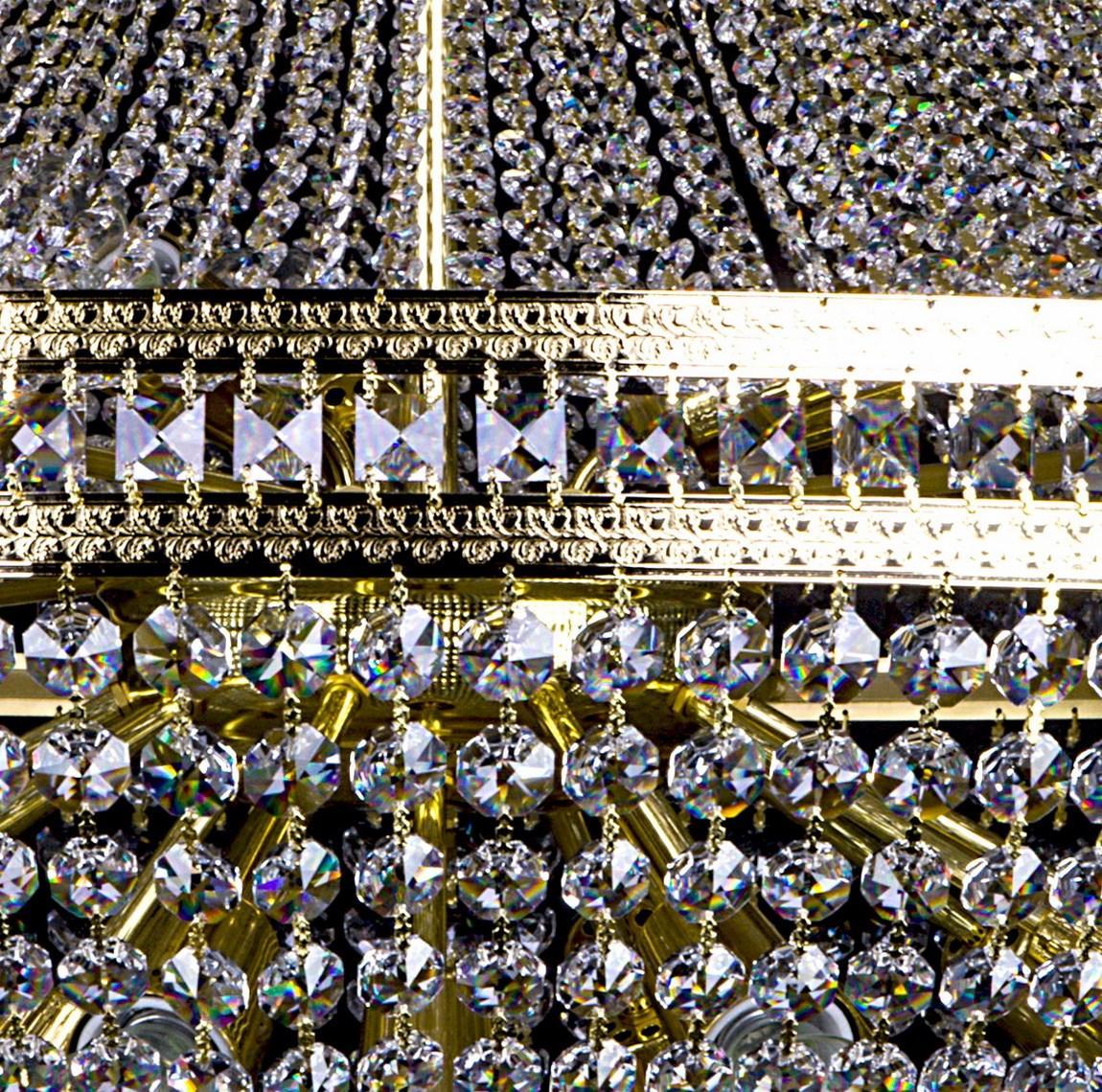 Détail des cristaux facettés et de la bande dorée ornée de perles et d'anneaux.