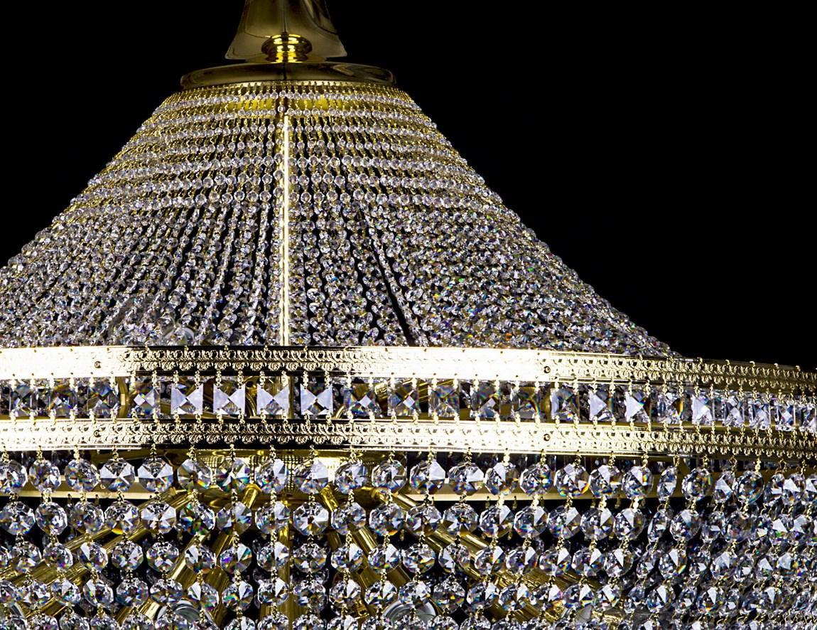 Gros plan du sommet conique, des chaînes de cristaux et des cercles dorés.