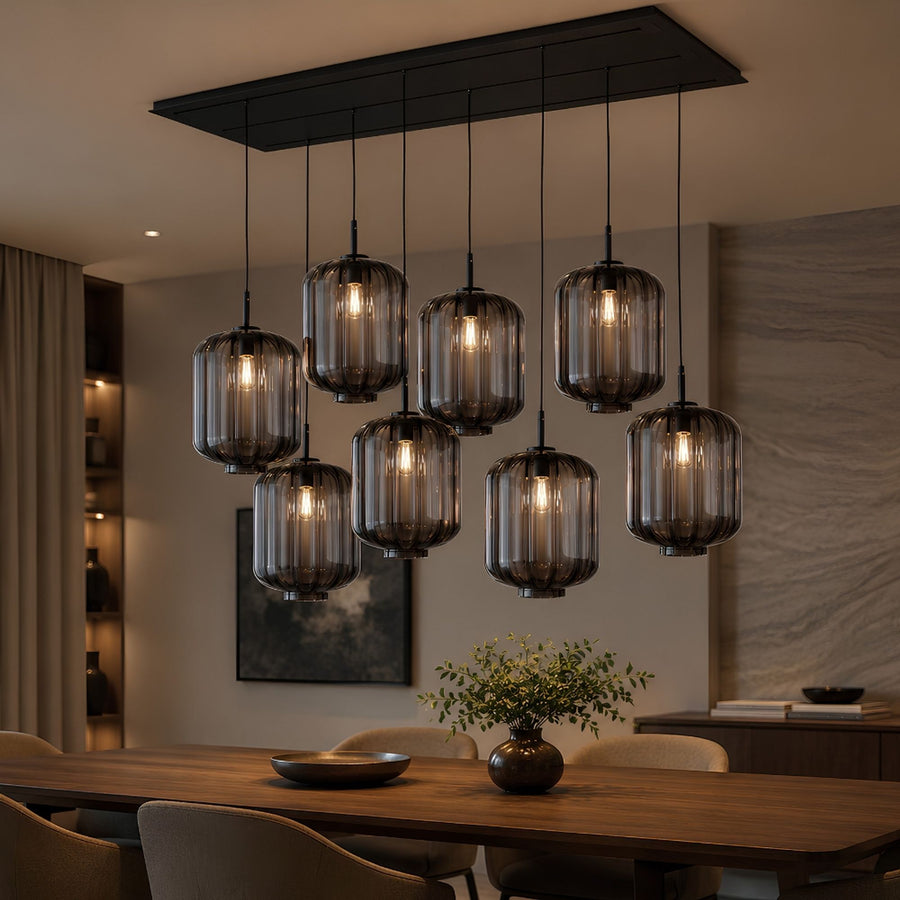 Suspension huit verres fumés cylindriques cannelés au-dessus d'une table en bois en intérieur