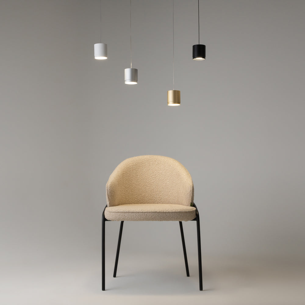 Quatre suspensions de coloris différents suspendues au-dessus d'une chaise beige