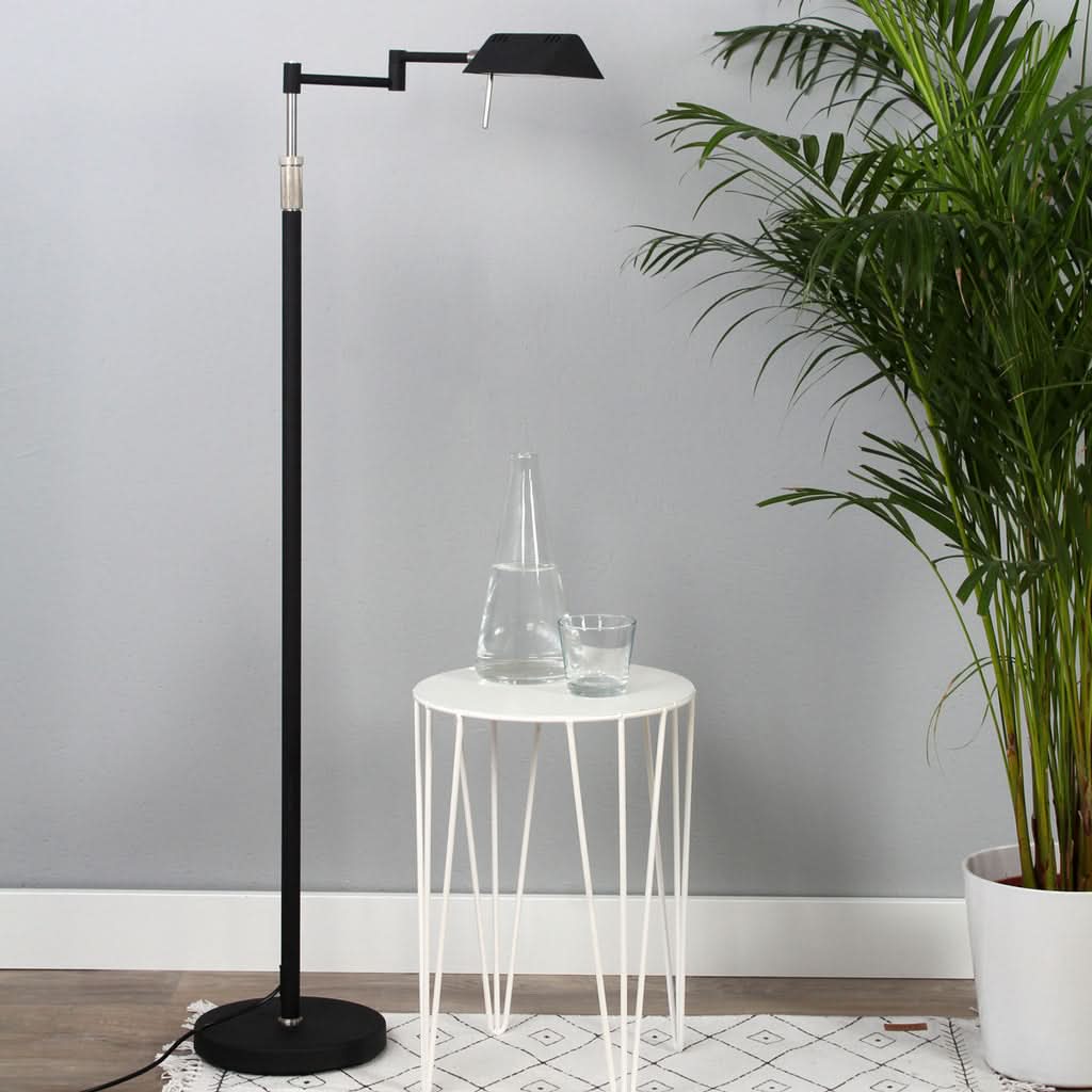 Mise en ambiance avec lampe sur pied noire près d'une table blanche et plantes.