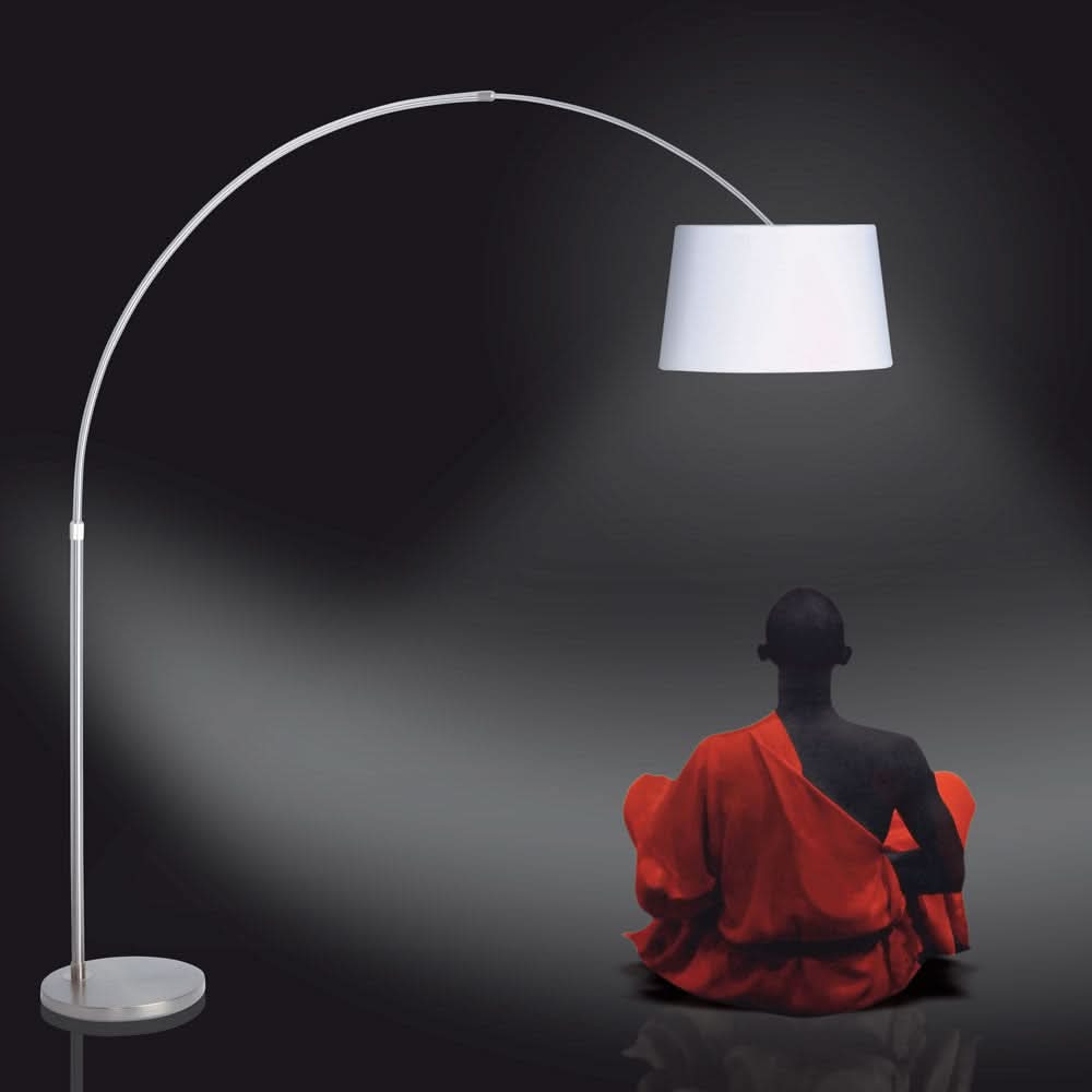 Scène sombre avec lampadaire arqué à abat-jour blanc et silhouette assise en robe rouge.
