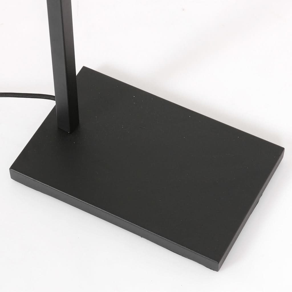 Détail de la base rectangulaire noire du lampadaire, avec câble d'alimentation apparent.
