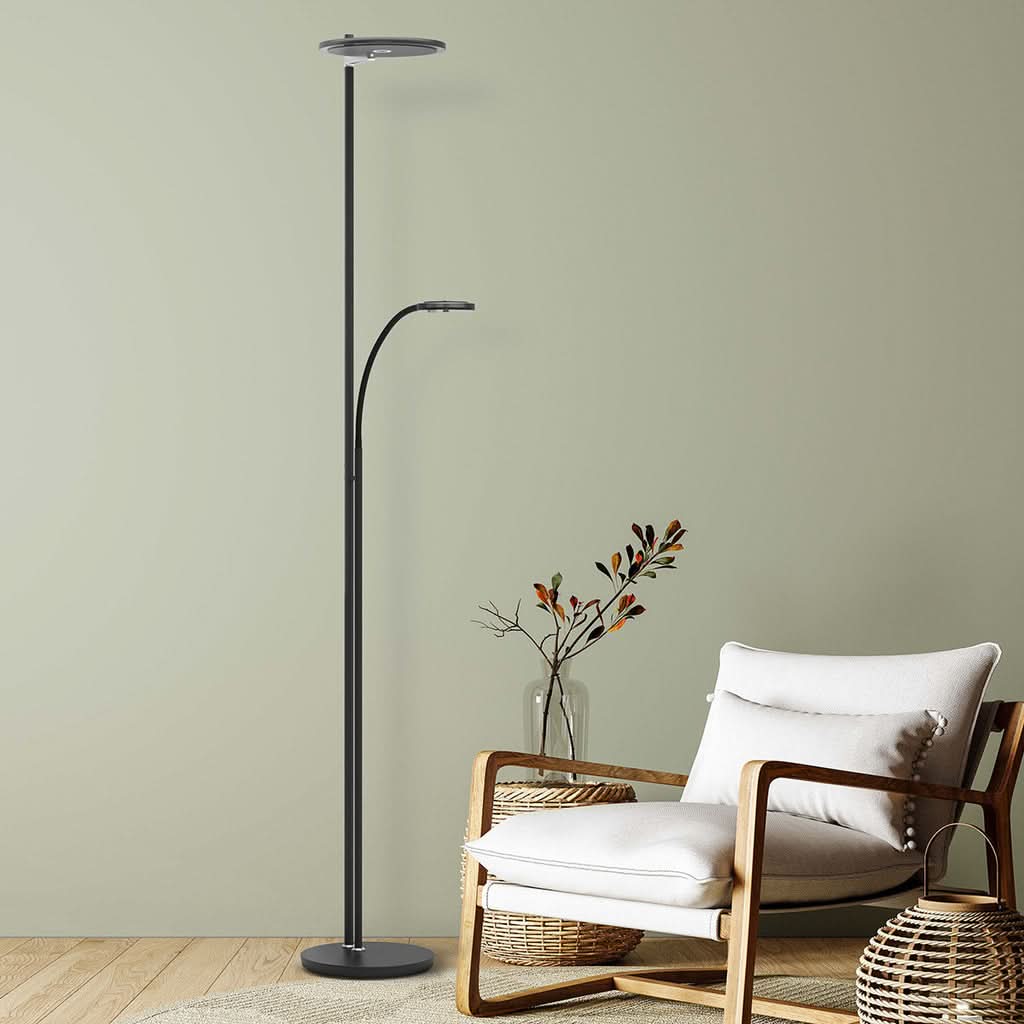 Scène d'intérieur avec fauteuil beige, mur vert et lampadaire noir allumé.