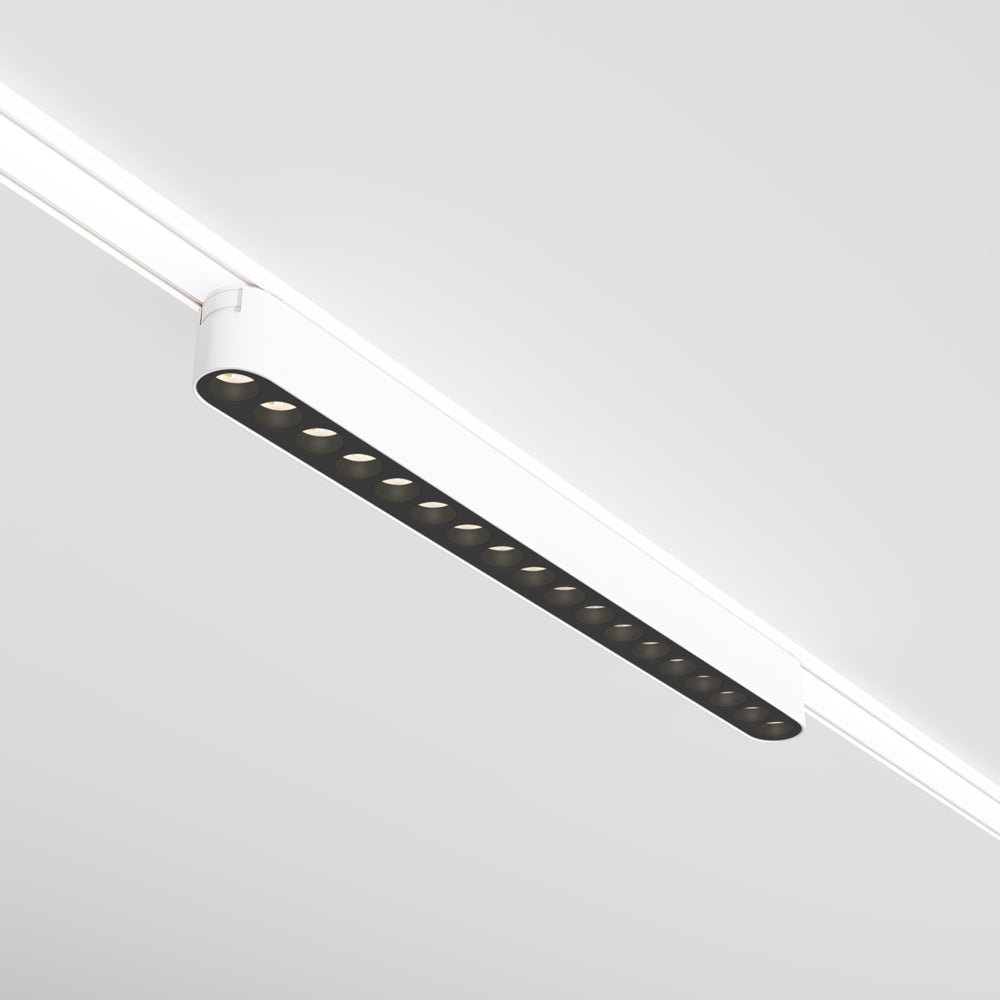 Vue rapprochée du luminaire blanc et de son rail, spots alignés.