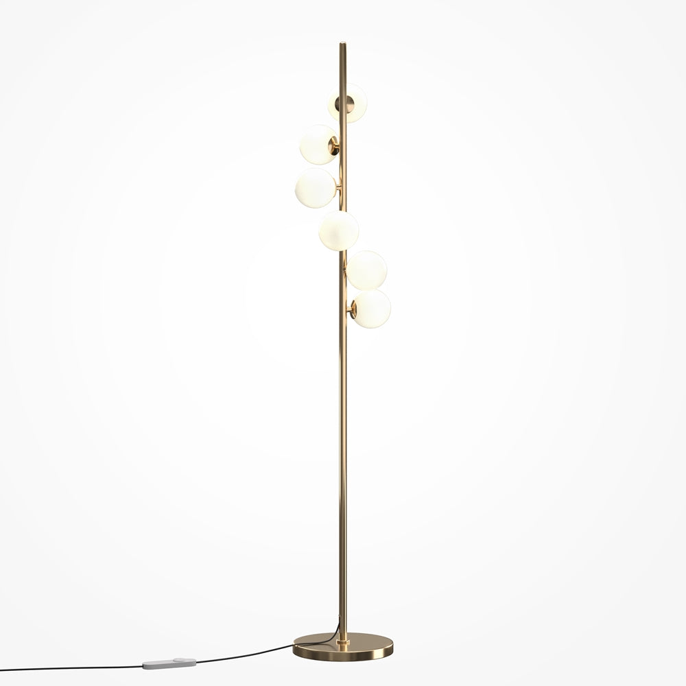 Lampadaire doré à globes opalins éclairés, tige verticale et base ronde