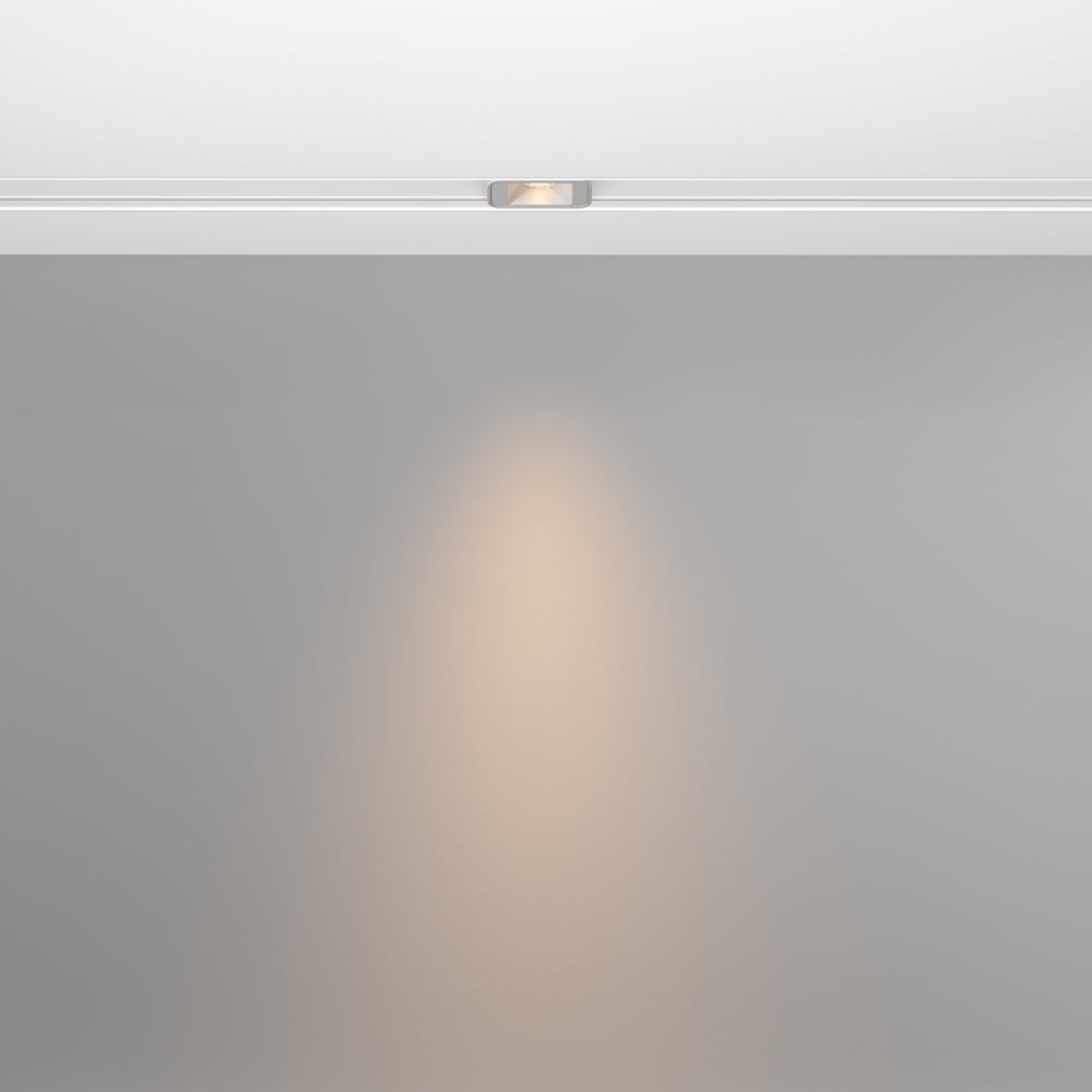 Mise en ambiance montrant le faisceau lumineux projeté sur un mur gris
