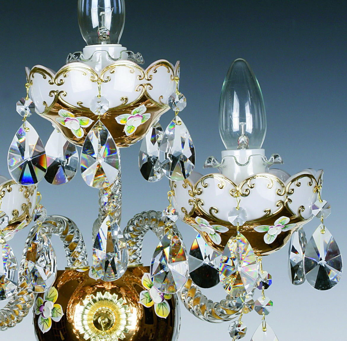 Détail rapproché d'une coupelle blanche et dorée avec rinceaux, fleurs peintes et pendants de cristal