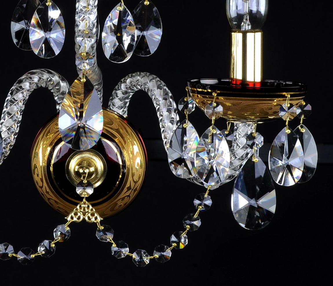 Gros plan du médaillon central et des bras courbes en verre, gouttes de cristal