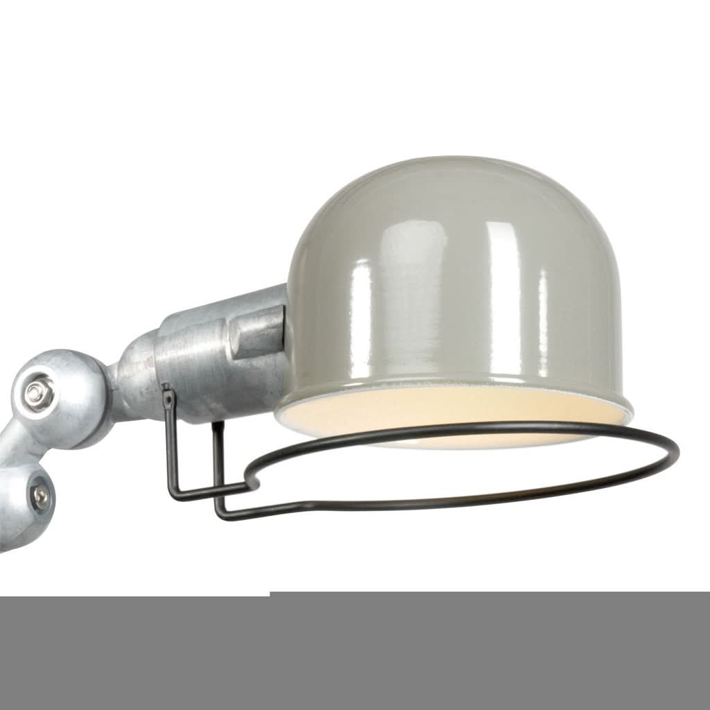 Gros plan sur l'abat-jour bombé brillant et la grille métallique circulaire