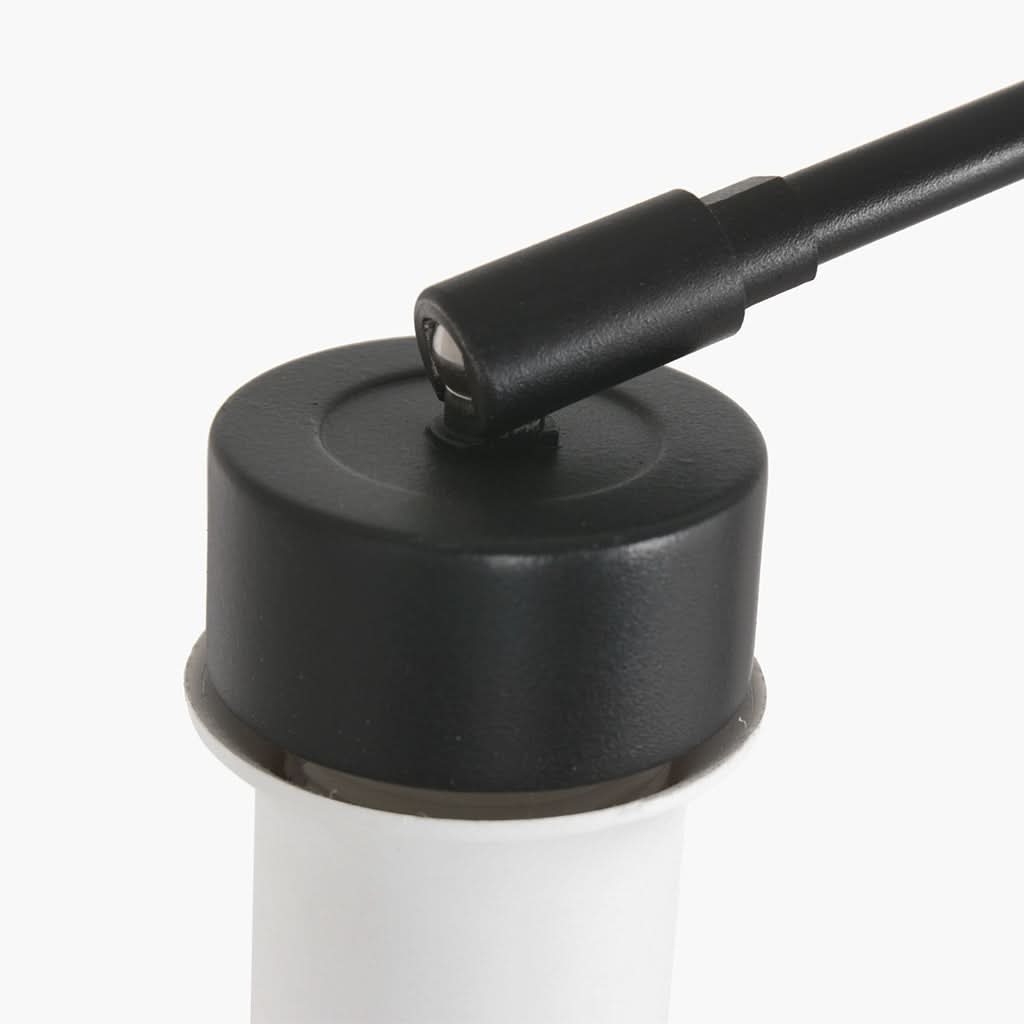 Détail du raccord noir au sommet du diffuseur blanc avec bras articulé.