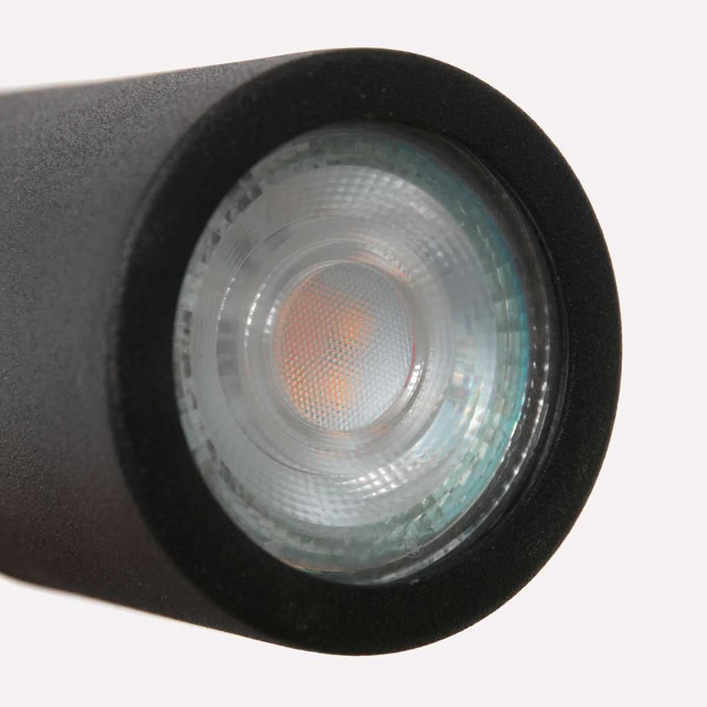 Détail de la lentille et du module LED éteint dans la tête cylindrique noire.