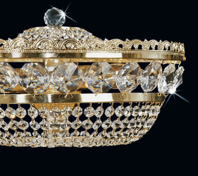 Gros plan sur la bague dorée ciselée et les chaînes de cristaux suspendus