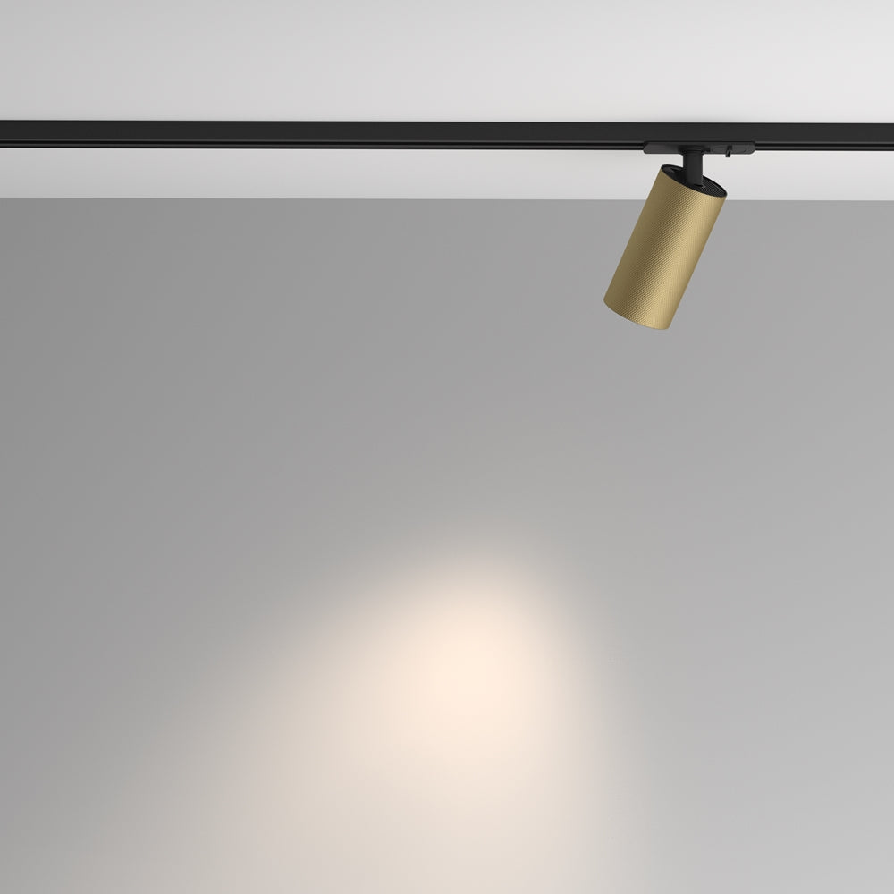 Mise en ambiance : spot orienté vers le mur, halo lumineux doux sur fond gris.