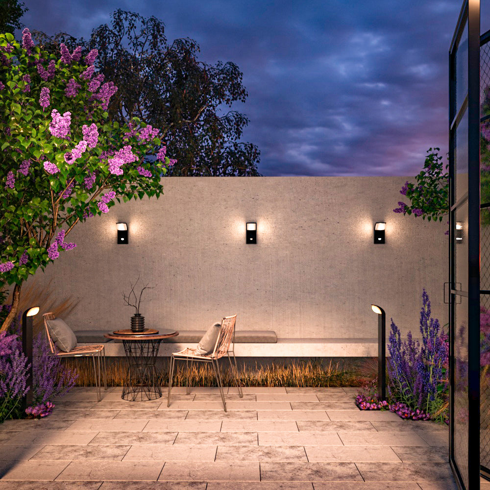 Mise en ambiance nocturne sur une terrasse avec trois appliques murales allumées