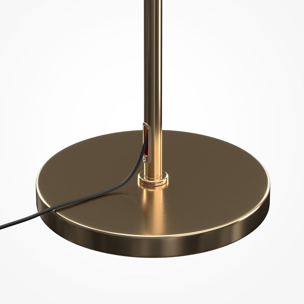 Détail de la base ronde dorée avec passage du câble électrique