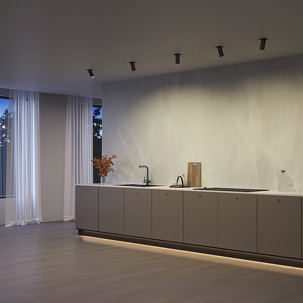 Mise en ambiance dans une cuisine moderne avec plusieurs spots alignés au plafond