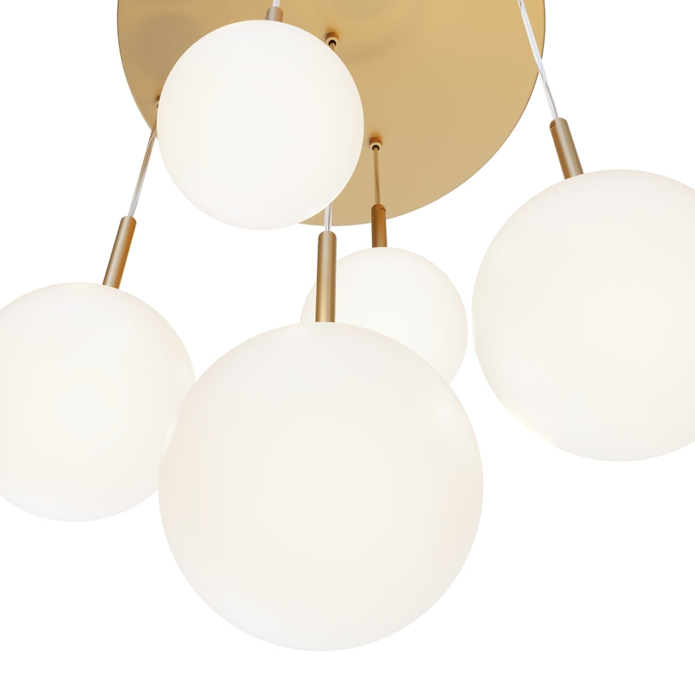 Détail rapproché des globes opalins et des tiges dorées fixées au plateau.