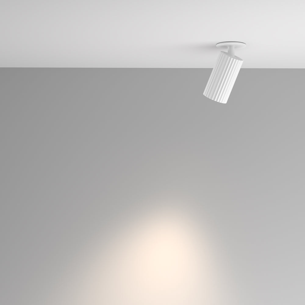 Mise en ambiance : le spot éclaire un mur gris de sa lumière chaude