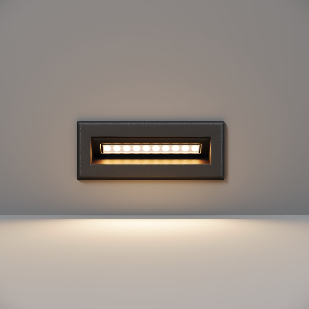 Version large noire, bandeau LED allumé éclairant le mur vers le bas