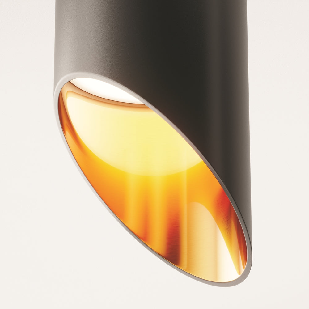 Détail rapproché du réflecteur doré aux reflets cuivrés à l'intérieur du cylindre noir