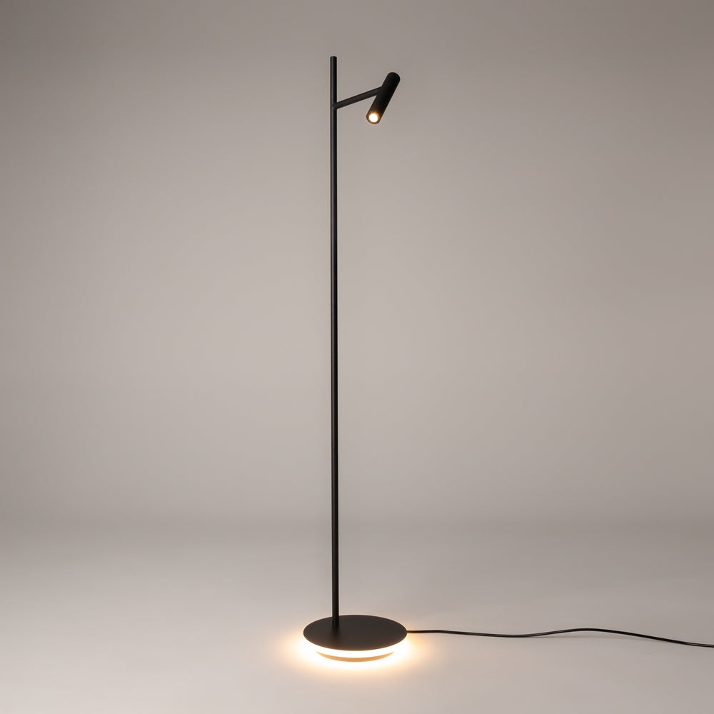 Vue entière du lampadaire allumé, projecteur cylindrique et base ronde diffusant une lumière chaude.