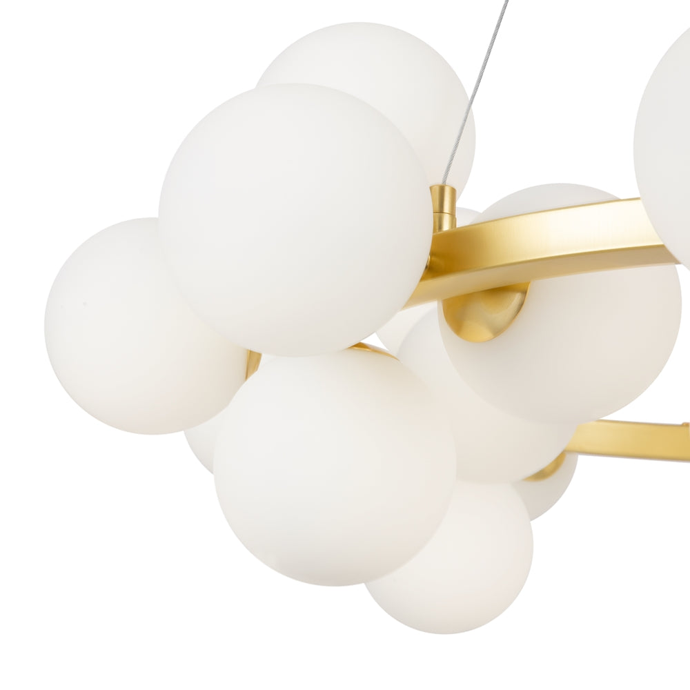 Gros plan sur les globes de verre opalin et l'anneau doré brossé du luminaire.