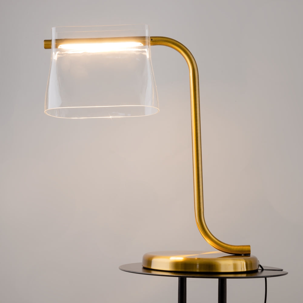 Lampe allumée de trois quarts, lumière chaude traversant l'abat-jour en verre