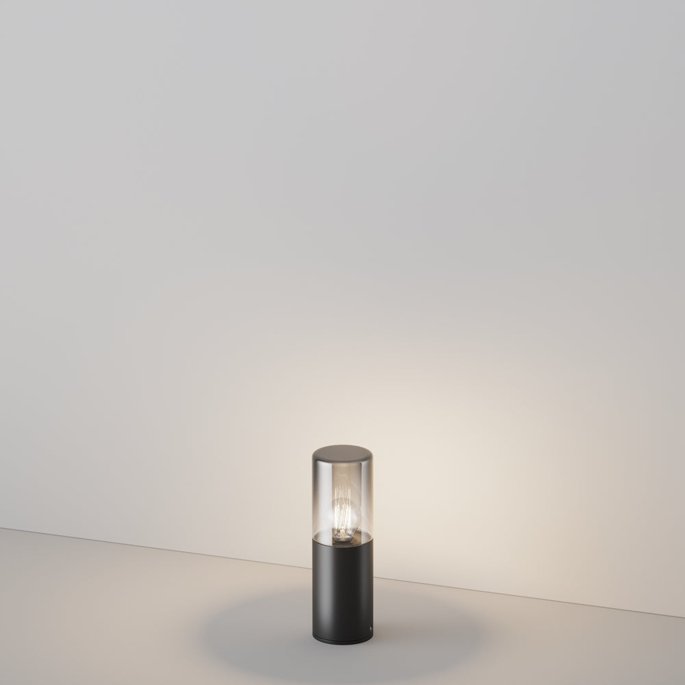 Version basse du luminaire cylindrique éclairant le sol dans une pièce vide