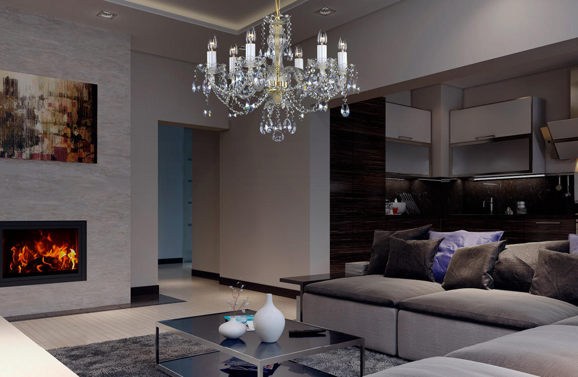 Lustre cristal suspendu au-dessus d'un séjour moderne, cheminée allumée et canapé gris.