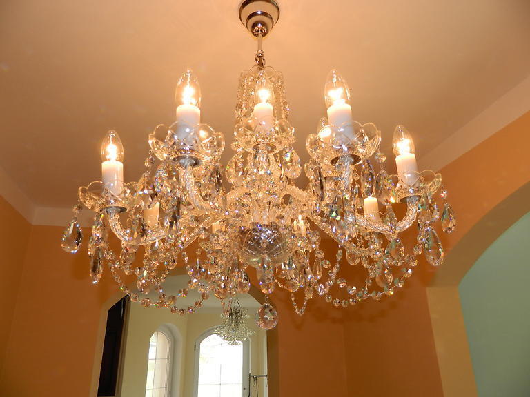 Lustre éclairé fixé au plafond dans une pièce aux murs ocre