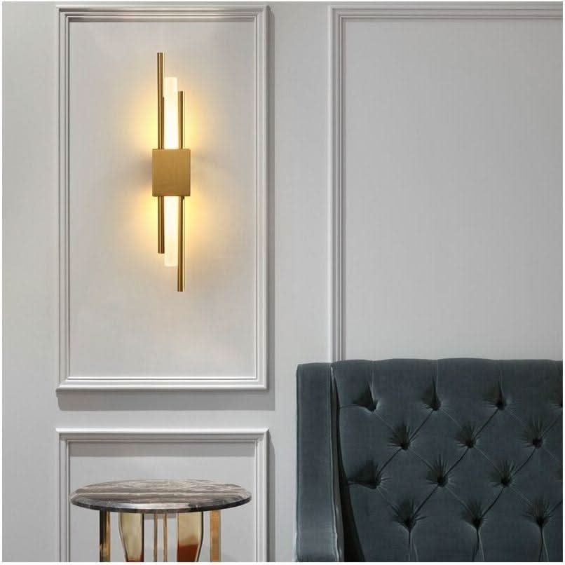 Applique dorée allumée sur boiserie blanche, au-dessus d'une table et d'un fauteuil